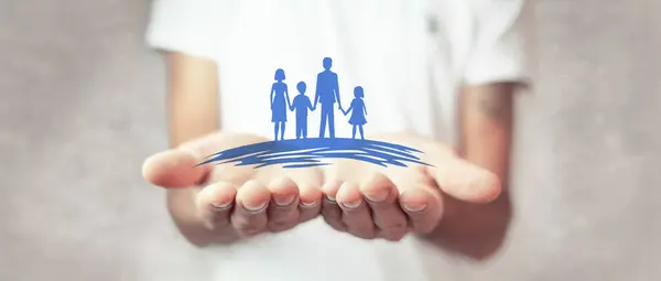 Aile sigortası konsepti. Bir aile evini elleriyle tutan bir iş adamı.