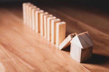 Bir yığın parası olan ahşap ev modeli. Emlak sigortası kavramı.