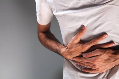 Beyaz arka planda karın ağrısı çeken bir adam.