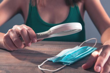 Beyaz tişörtlü genç bir kız maskeli yoga egzersizleri yapıyor. Koronavirüs salgını.