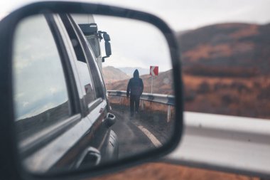 Aynadaki adam ve yoldaki araba görüntüsü
