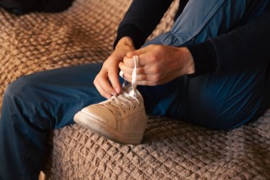 Ayakkabı bağcığını bağlayan adam