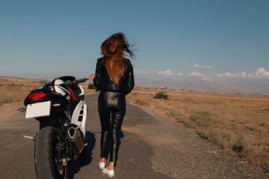 Siyah ceketli ve motosikletli bir kız..