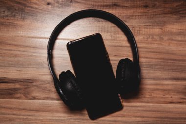 Masa arkasında kulaklık ve akıllı telefon, üst görünüm