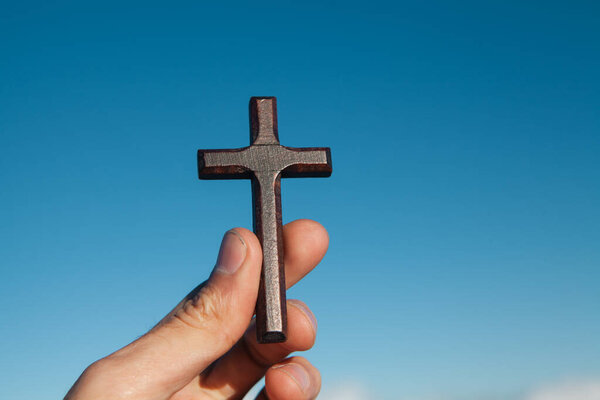 cross on the hand of the man.