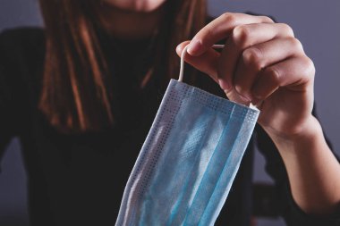 Kız yüzüne tıbbi maske takıyor..