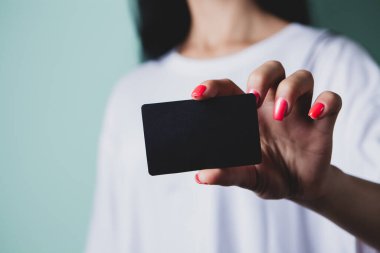 Kadının elinde gri arka planda siyah hediye kutusu var.