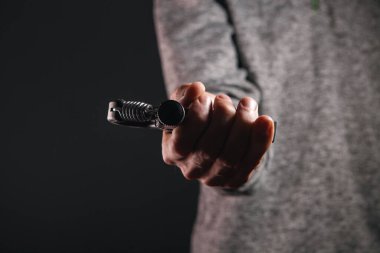 Spor giyimli, elinde dambıllar olan bir sporcunun kırpılmış görüntüsü.