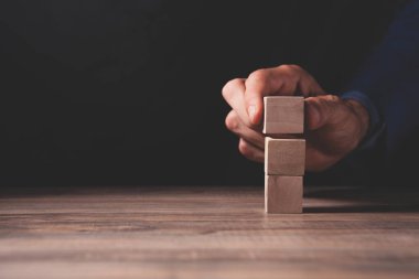 Adam elinde bir domino taşını tutuyor. 