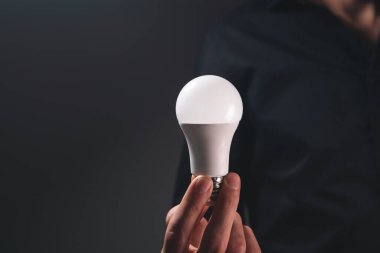 Adamın elinde ampul var.