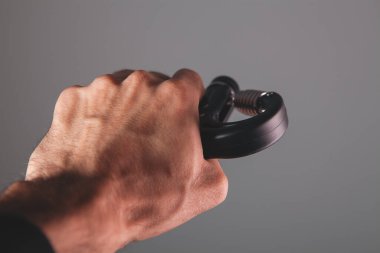 Spor giyimli, elinde dambıllar olan bir sporcunun kırpılmış görüntüsü.