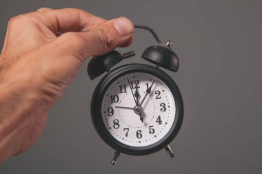 Bir çalar saat tutan el