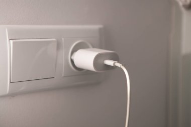 Duvarda fişi olan beyaz elektrik soketi