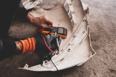 Elektrikçi motorsiklet kablolarını test ediciyle kontrol et