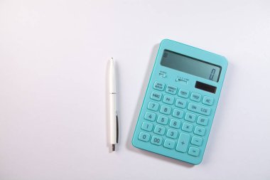Hesap makinesi ve kalem beyaz arkaplanda. en üstteki görünüm