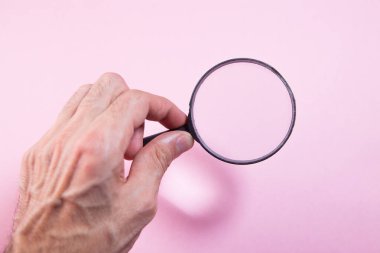 Kadın eli büyüteç tutuyor.