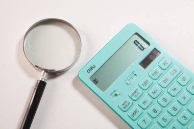 Hesap makinesi, kalem ve büyüteç