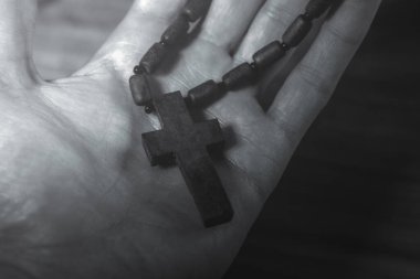 Beyaz arka planda ahşap tespihi tutan el.