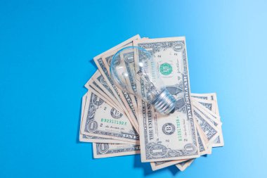 100 dolarlık banknotlarla dolu mavi bir kavanozda dolar.