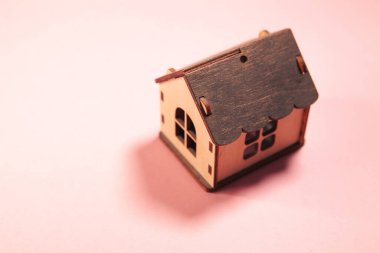 Pembe arka planda ağaç şeklinde bir model ev.