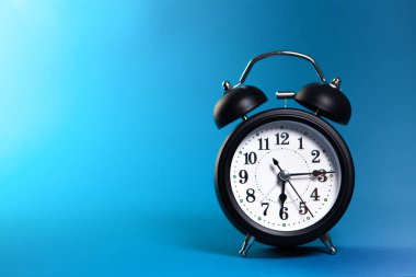 Mavi arka planda çalar saat. Zaman kavramı. Kapat..