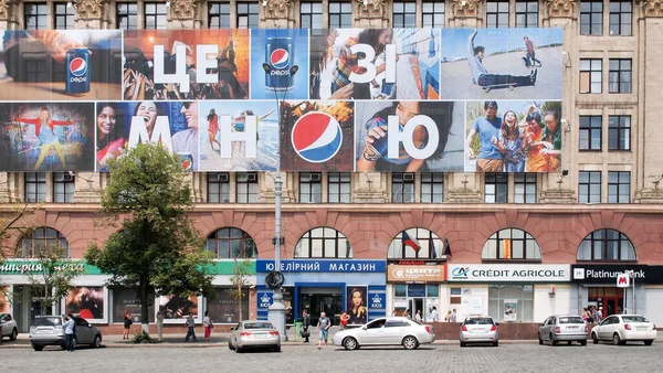 Kharkiv, Ukrayna - 30 Haziran 2013: Bir şehir binasının ön cephesinde ünlü bir markanın reklam işareti. Diyor ki, yanımda Pepsi var. Yedi hafif araba aşağıda park halinde. Pepsi ışığın içkisi.!