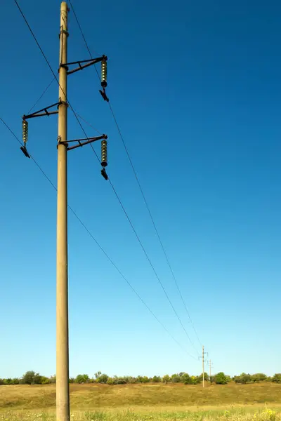 Elektrik yüksek voltaj direği. Kırsal alan. Elektrik hatları. Yakın plan. Dikey yönelim.