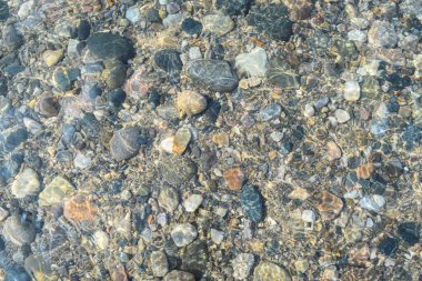 Temiz su, nehir yatağında uzanan çeşitli renkli çakıl taşlarını ve taşları ortaya çıkarır. Güneş ışığıyla aydınlatılır. Yüzeyden süzülerek barışçıl bir atmosfer yaratır..