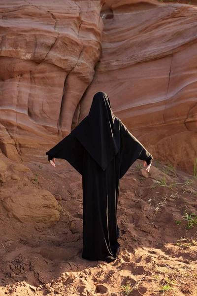 Müslüman kadın ulusal giyinmiş ve kanyonda dans ediyor.