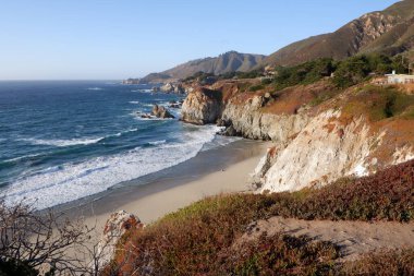 Pasifik Okyanusu 'nun yüksek açılı kıyı şeridi ve yukarıdaki kayalıklardan kumsal manzarası