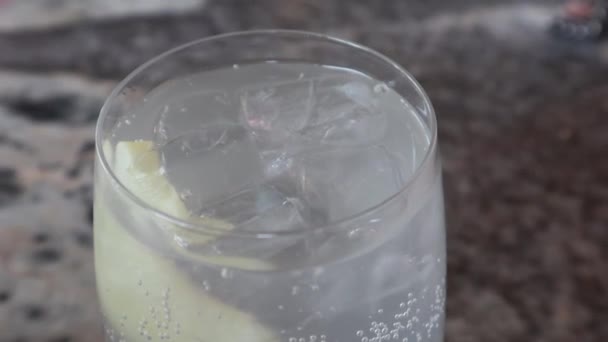 ガラスの前景ガラス瓶で提供されるレモン泡状の固定トニックソーダドリンクと輝く水 — ストック動画
