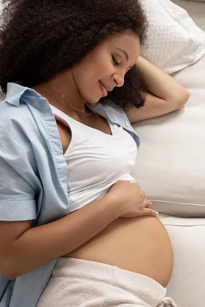Hermosa Mujer Embarazada Negra Disfrutando Maternidad Acariciando Barriga Tumbada Sofá —  Fotos de Stock