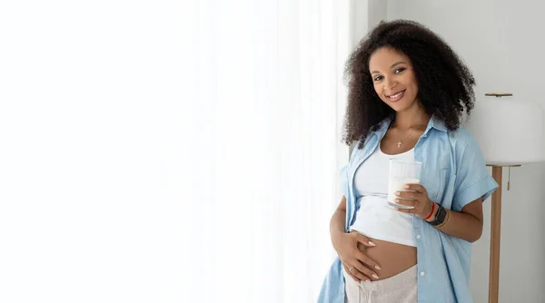 Mujer Embarazada Negra Que Bebe Leche Sonríe Cámara Acariciando Barriga —  Fotos de Stock