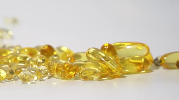 Detailní Pohled Průhledné Zlaté Pilulky Bílém Pozadí Olejové Pilulky Kapsle — Stock video