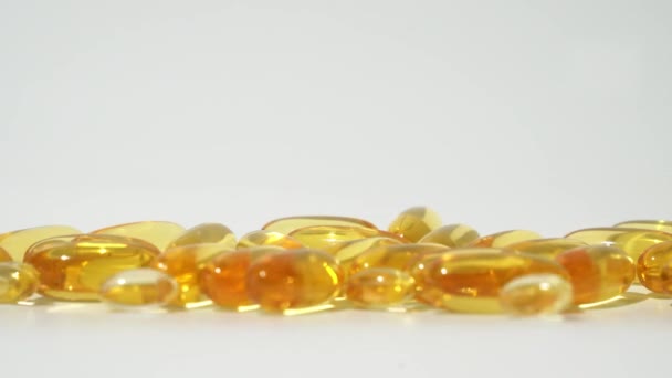 Průhledné Zlaté Pilulky Padající Bílé Pozadí Olejové Pilulky Kapsle Péče — Stock video