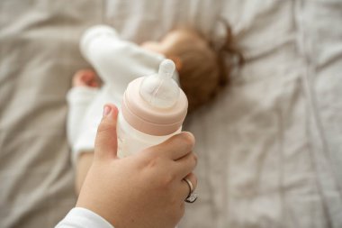 Bebek şişesini süt ya da formülle kapat. Bulanık çocuğu yatağa yatır. Uyumadan önce beslenme kavramı