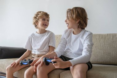Cute children joyful playing video games with controller console, brother sister expressing emotions while enjoying their hobby playstation joystick