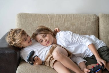 Cute children joyful playing video games with controller console, brother sister expressing emotions while enjoying their hobby playstation joystick