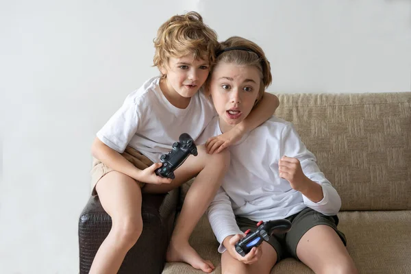 Addicted children playing video game playstation joystick controller at home. Harm of online gadget entertainment technology to human health. Copy space