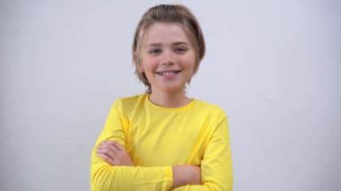 Portrait Of Smiling Handsome Teenager Boy Long Hair in Yellow T-Shirt Looking At Camera Over white Background. Positive Teen Mood. Advertising Copy Space