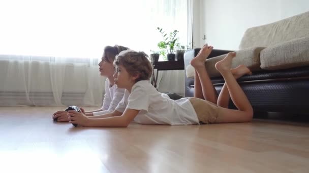 ゲーマー駅ジョイスティックを使用して テレビの前でビデオゲームをプレイする兄弟姉妹 子供たち兄弟姉妹は自宅で趣味のレジャー活動を楽しんでいます — ストック動画