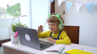 Schoolboy child using laptop and headphones online educational lesson course at home. Distance learning remote video conference. Schoolgirl study does school homework. Child call with relatives friend