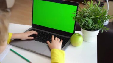 Klavye bilgisayarında daktilo eden zeki, beyaz bir ilkokul çocuğu. Çevrimiçi öğretmenlik, dijital dersler, evde bilgisayar programlama. Sanal eğitim. Öğrenci kız ders çalışıyor.