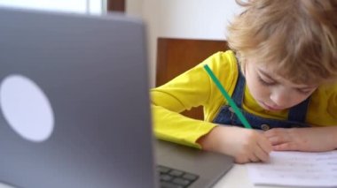 Close up Schoolboy child write exercise alphabet using laptop online educational lesson programming course at home. Distance learning remote video conference. Schoolgirl study does homework.