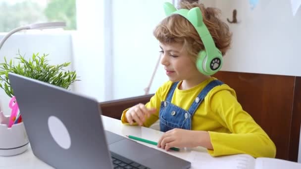 Cute Smart Caucasian Primary School Child Headphones Educate Online Laptop — Vídeo de Stock