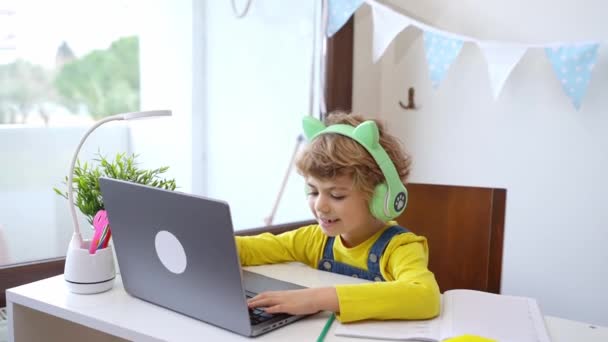 Симпатичный Умный Ребенок Младшего Школьного Возраста Наушниками Клавиатуре Ноутбука Онлайн — стоковое видео