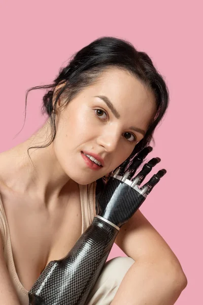 Slim Disabled Woman with Prosthetic Arm, Artificial Hand Smiling To Camera Over Pink Background. Women Beauty Diversity. Positive. Copy space Vertical