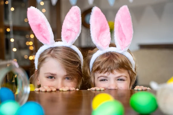 Happy family Easter. Funny kids play game with painted eggs at home. Funny kids play Easter hare hunters