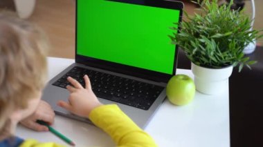 Klavye bilgisayarında daktilo eden zeki, beyaz bir ilkokul çocuğu. Çevrimiçi öğretmenlik, dijital dersler, evde bilgisayar programlama. Sanal eğitim. Öğrenci kız ders çalışıyor.