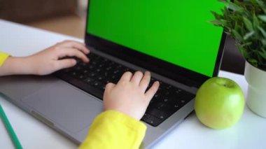 Klavye bilgisayarında daktilo eden zeki, beyaz bir ilkokul çocuğu. Çevrimiçi öğretmenlik, dijital dersler, evde bilgisayar programlama. Sanal eğitim. Öğrenci kız ders çalışıyor.